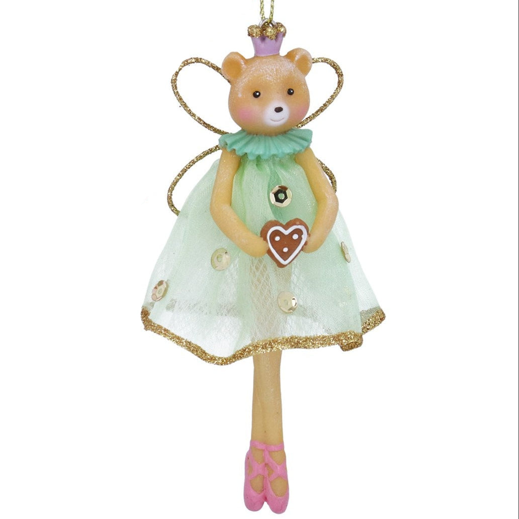 Decorative figurine of a fox in a green dress with a heart-shaped cookie, on a white background.