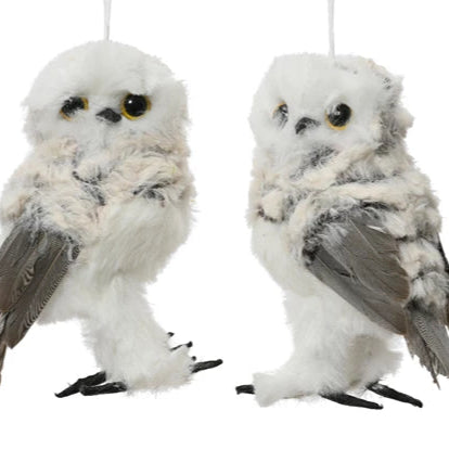 Two plush snowy owl ornaments hanging against a white background