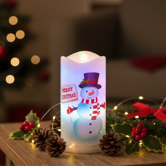 A cylindrical LED candle-style lamp with a glowing white body and a printed snowman design holding a 'MERRY CHRISTMAS' sign. The lamp is shown on a plain white background with colorful light leaks around the edges.