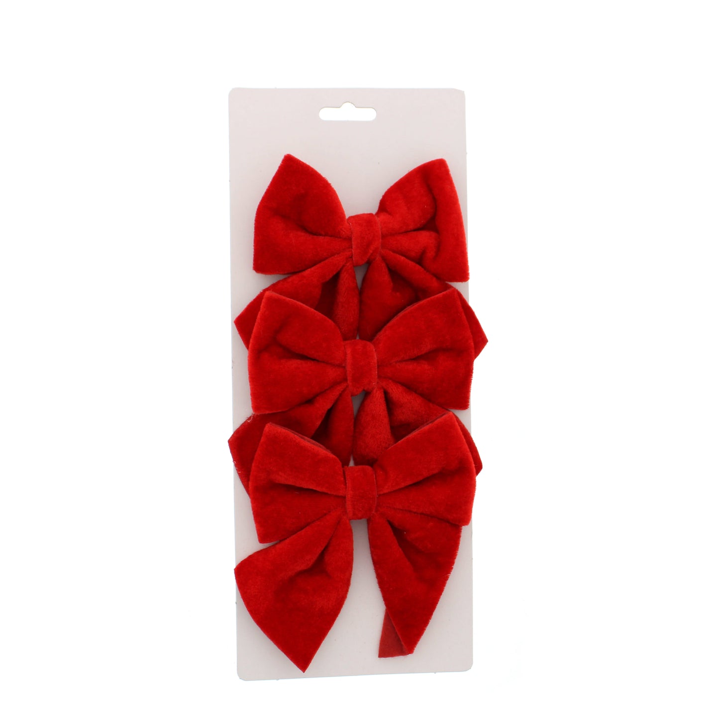 Three red velvet bows stacked vertically on a white cardboard hanger display, photographed against a solid white background.