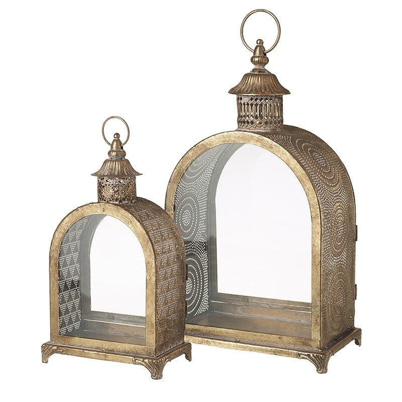 A set of two gold metal lanterns with glass panels, featuring intricate patterns and designs on the lantern bodies.
