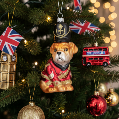 A Christmas tree decorated with London-themed ornaments, including a central bulldog figurine in a red uniform and black hat, a red double-decker bus, a Big Ben tower ornament, and Union Jack flags.