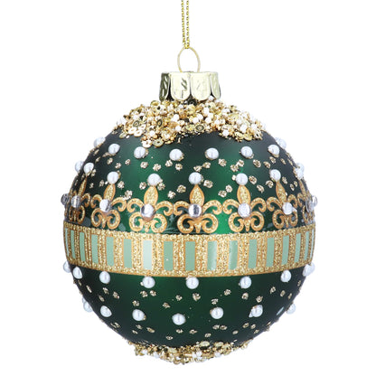 A green glass Christmas ornament decorated with gold metallic patterns, faux pearls, and rhinestones, hanging from a gold string against a white background.