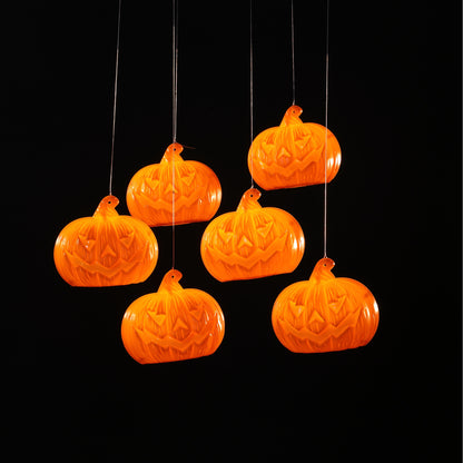 Hanging orange pumpkin decorations on a black background