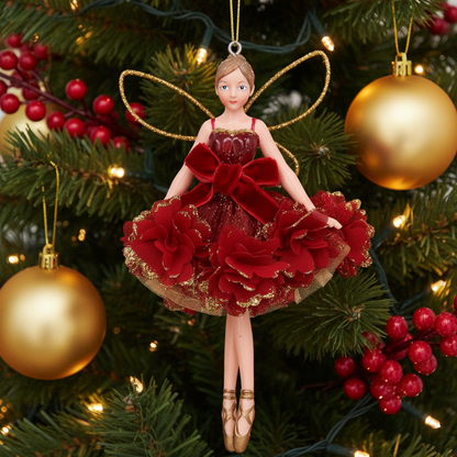 A ballet fairy Christmas ornament featuring a female figure in a red velvet and tulle tutu dress with gold accents, gold wire wings, and a hanging loop, shown against a Christmas tree background.