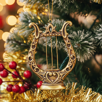 An ornate gold and bronze lyre-shaped hanging ornament with decorative scrollwork and a hanging loop at the top, shown against a plain white background.