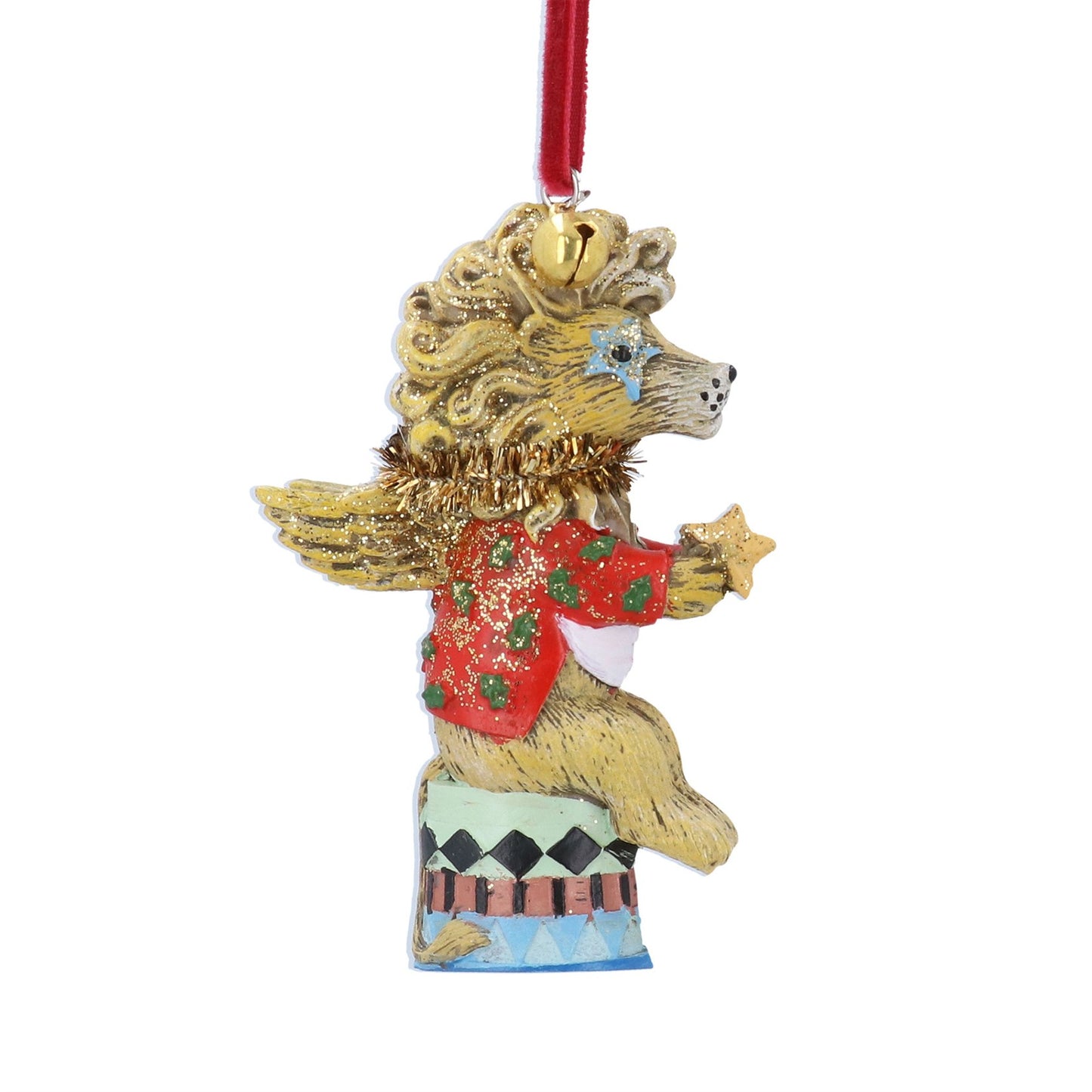 A whimsical lion angel Christmas ornament with a gold body, red sweater with green stars, and a red hanging ribbon, shown against a plain white background.