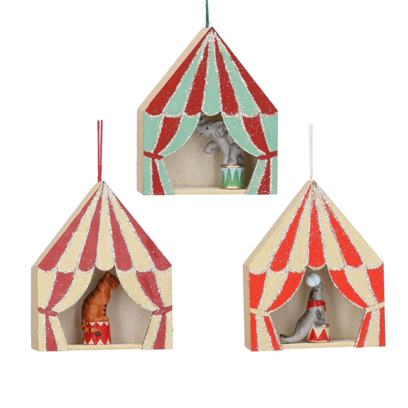 Three small circus tent ornaments hanging against a white background, each with a different animal figurine inside. The top tent is mint green and red, and the two lower tents are cream and red.