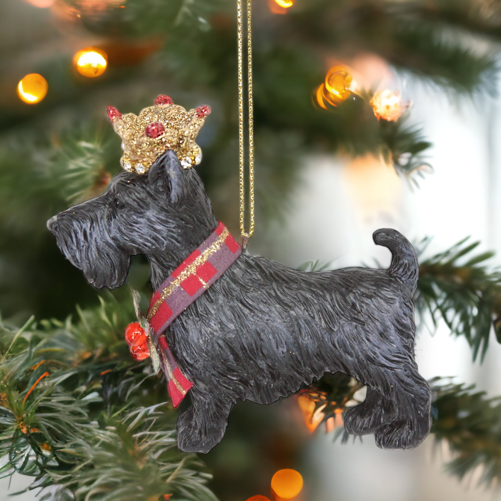 A hanging Christmas tree decoration featuring a black Scottie dog with a gold crown and a red and white tartan collar.