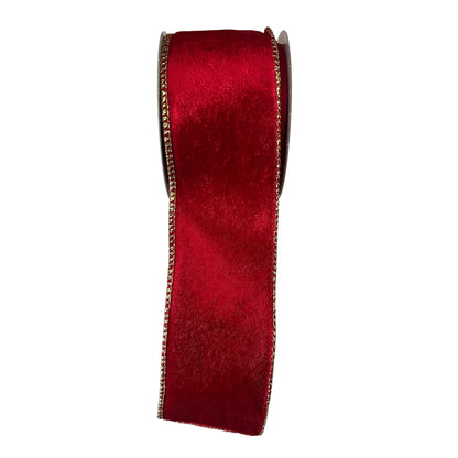 Red velvet ribbon with gold edge on a  white surface