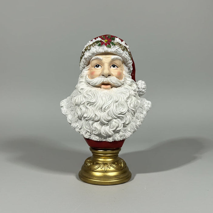 A Santa Claus bust figurine with a white beard, red hat, and gold base, plain background