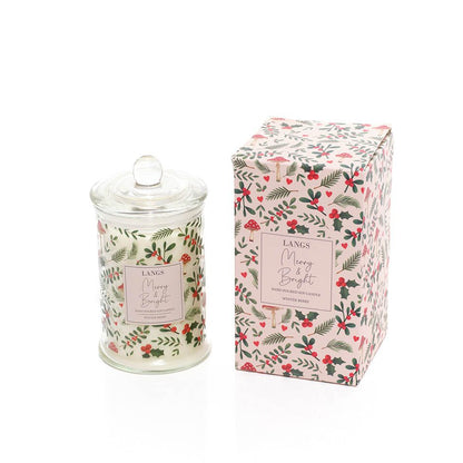 A Langs Merry & Bright scented candle in a clear glass jar with a lid, shown next to its matching floral-patterned packaging box on a white background.
