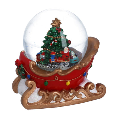 Christmas-themed snow globe with Santa Claus and a tree on a red sleigh base.