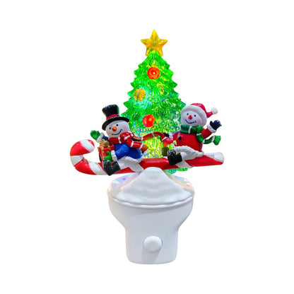 A Christmas-themed night light featuring a glowing green Christmas tree, two snowmen figures, candy canes, and a white toilet base on a plain white background.