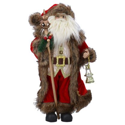 A Santa Claus figurine or decorative statue wearing a red suit with brown faux-fur trim, holding a staff and a small lantern, photographed on a plain white background.
