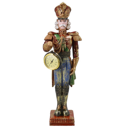 A decorative nutcracker figurine featuring a detailed military uniform in gold, blue, and green, holding a round clock face in one hand, set against a plain white background.