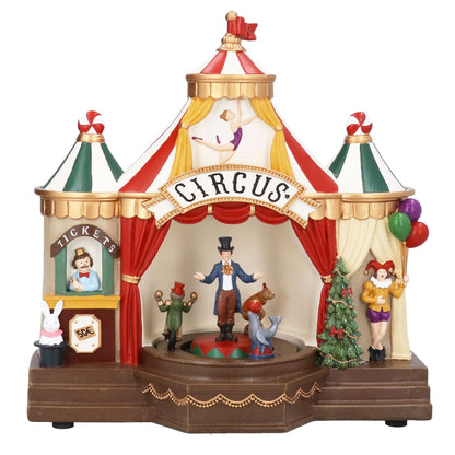 Decorative circus-themed music box with performers and a Christmas tree on a white background