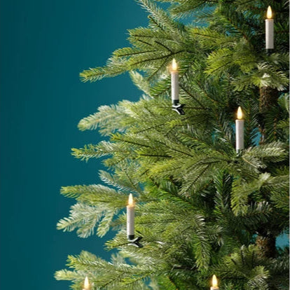 Decorative Christmas tree with small candles against a teal background