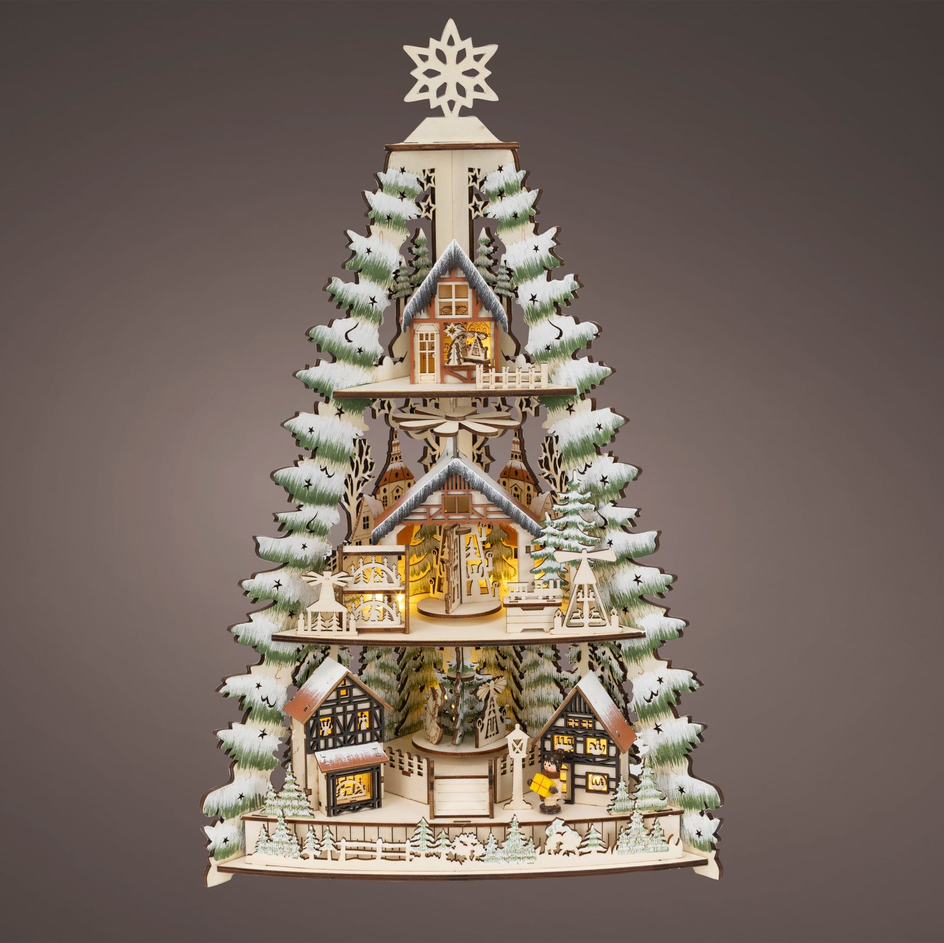 Decorative Christmas tree with houses and lights on a gray background
