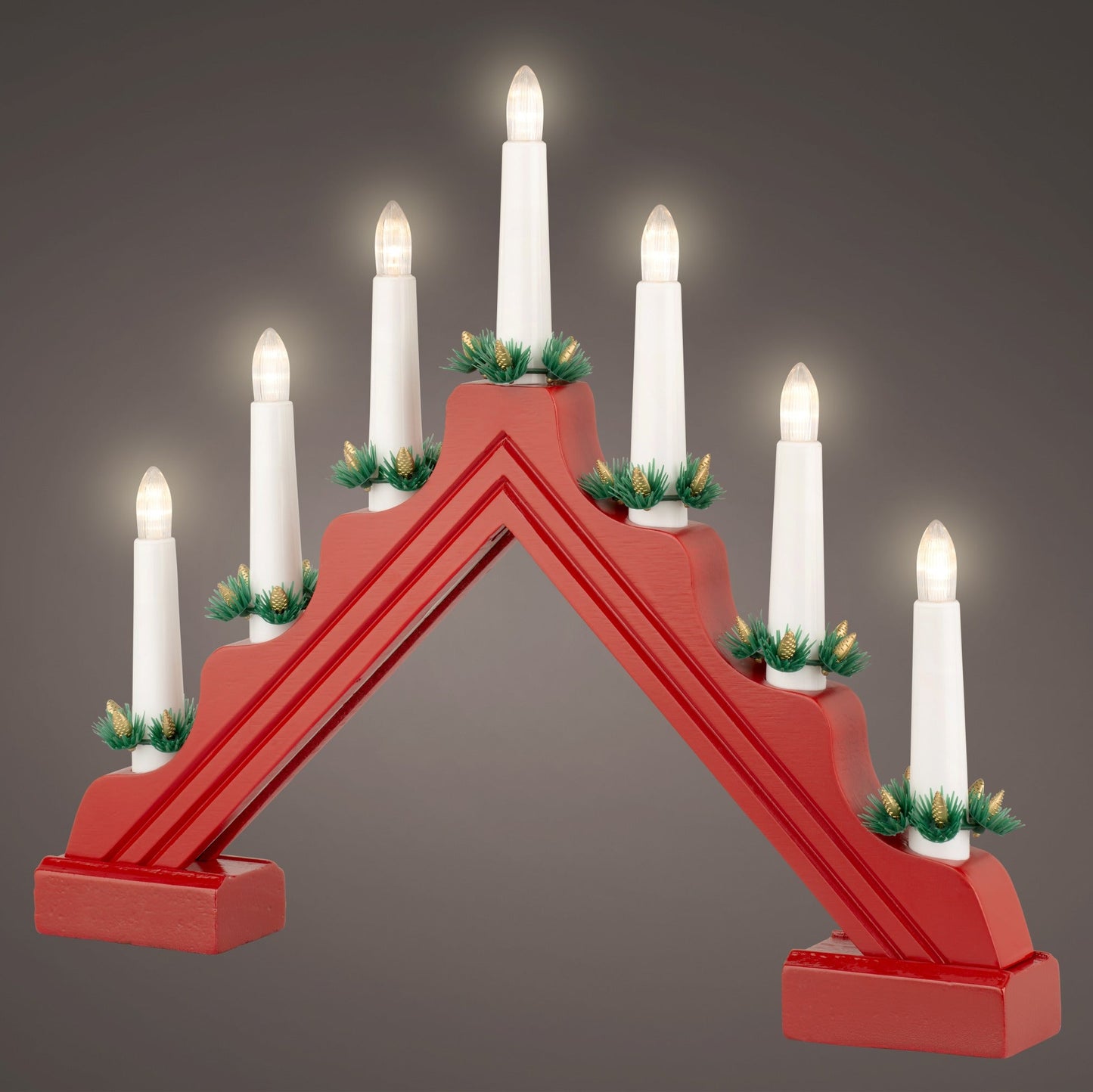 Red candle holder with white candles on a gray background