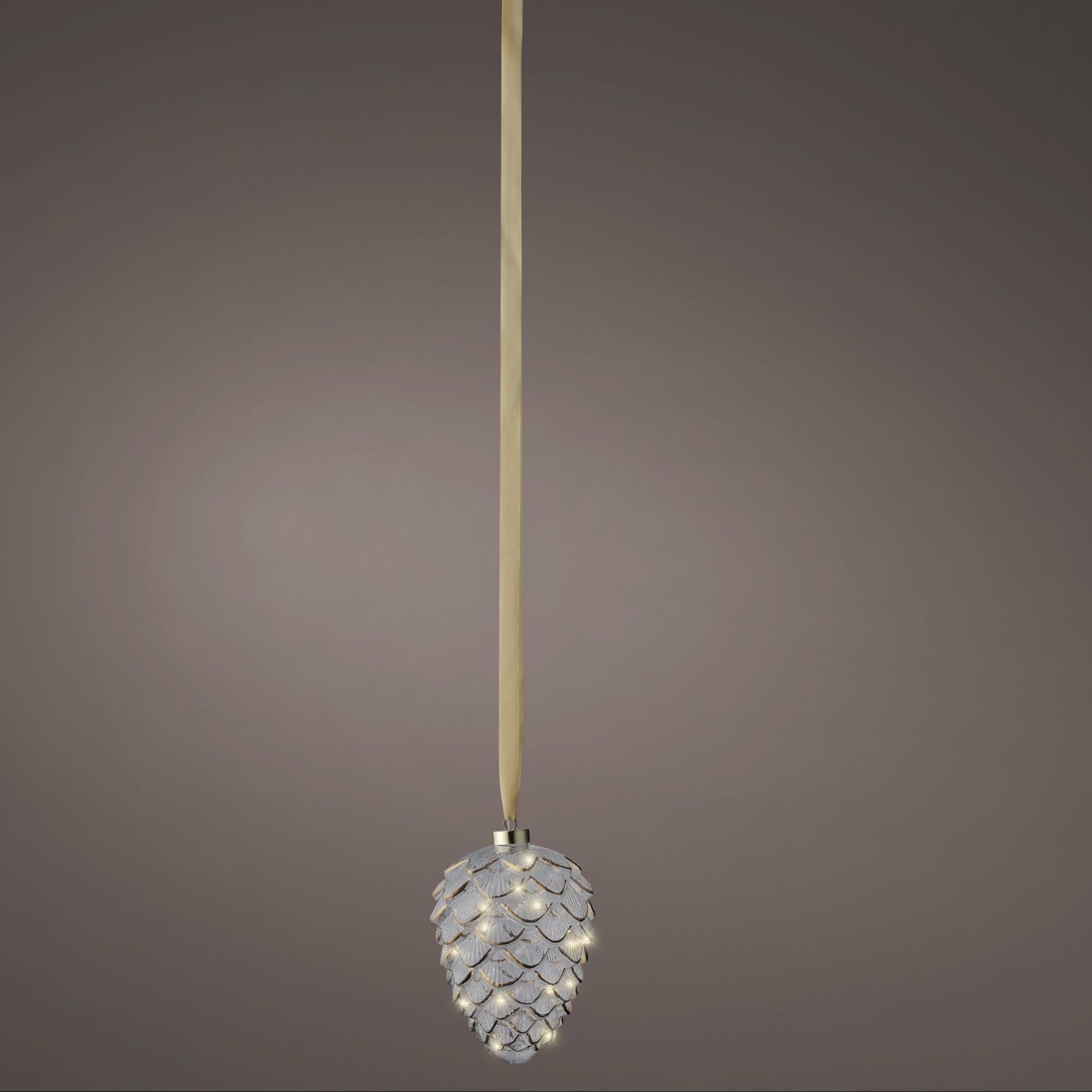 Decorative pine cone ornament with a long ribbon on a gray background