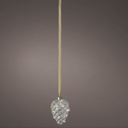 Decorative pine cone ornament with a long ribbon on a gray background