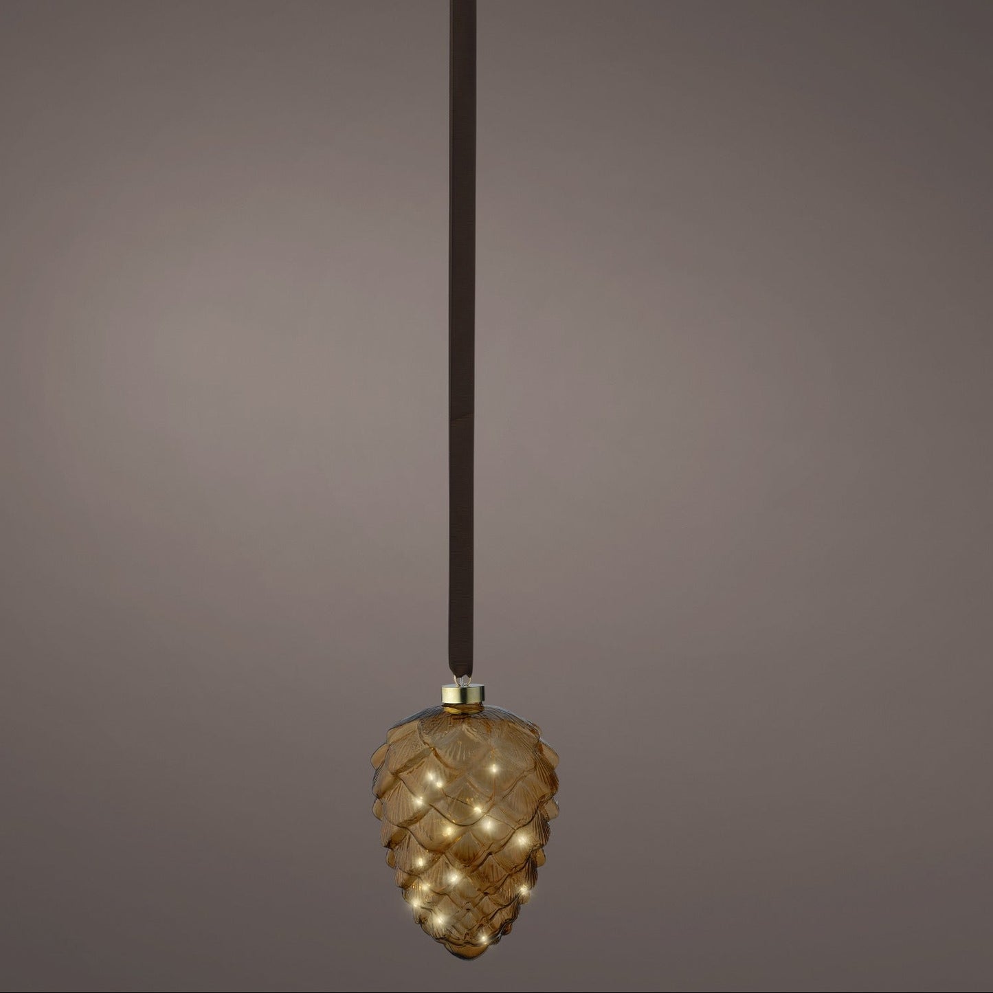 Decorative pendant light with a textured design on a dark background
