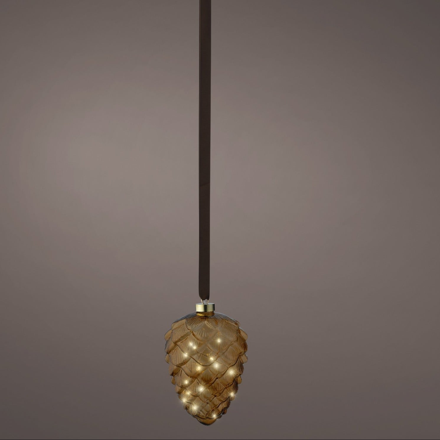 Decorative pendant light with a textured design on a dark background