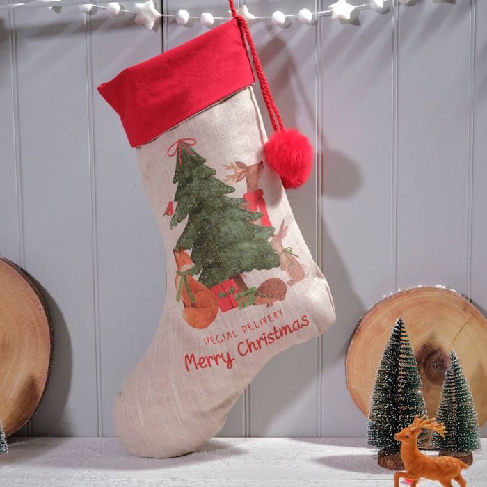A beige Christmas stocking with a red pom pom, featuring a Christmas tree and 'Merry Christmas' text, displayed against a grey background with decorative elements.