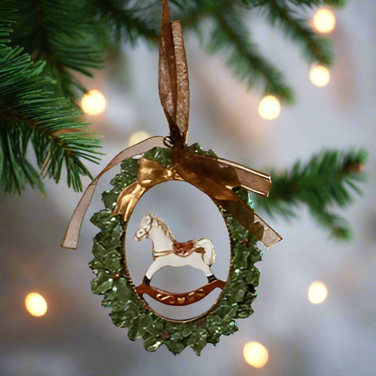 Decorative Christmas ornament with a horse silhouette on a green wreath.