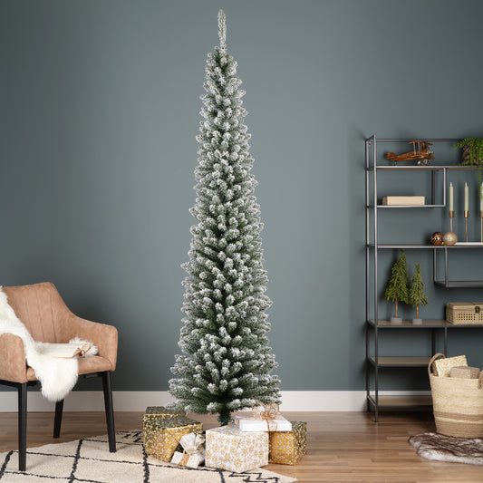An artificial Christmas tree with a slim profile featuring snowy effect branches, placed in a room with a metal base. The tree is decorated with presents and has a realistic appearance.