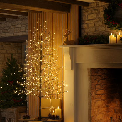 Warm white LED tree lights on a decorative branch-style lighted tree, styled in a cozy fireplace room with candles, stone walls, pinecones, and a wrapped gift.