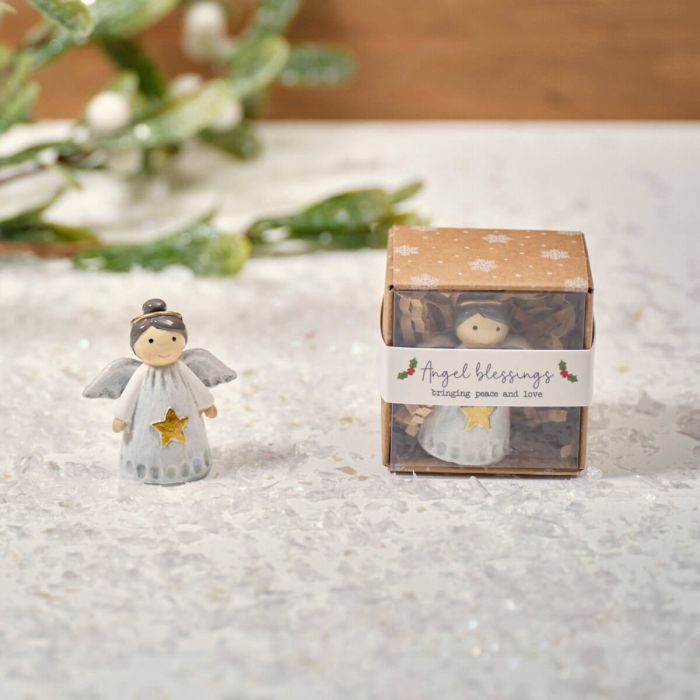 A small resin angel figurine next to its packaging box, which has 'Angel Blessings' written on it.