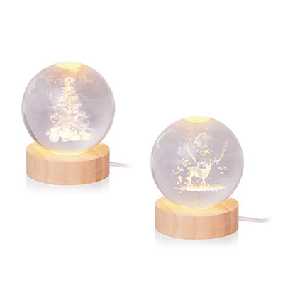 Two small LED glass globe lights with wooden bases, one featuring a Christmas tree and the other a deer, on a white background.