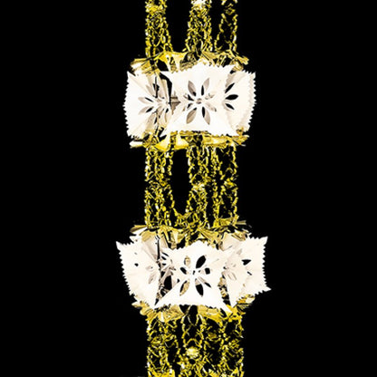 A close-up of a gold and ivory retro foil garland, snowflake-like decorative charms, set against a solid black background.