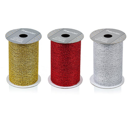 Three spools of glitter ribbon on a white background, in gold, red, and silver. Each spool has a gray cardboard top label with the brand name Premier.