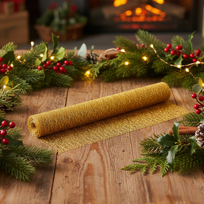 A roll of textured gold glitter mesh or tulle fabric, partially unrolled to show its fine, sparkly texture against a plain white background.