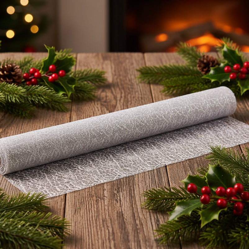 A roll of silver glittery fabric or mesh material partially unrolled, shown against a plain white background.