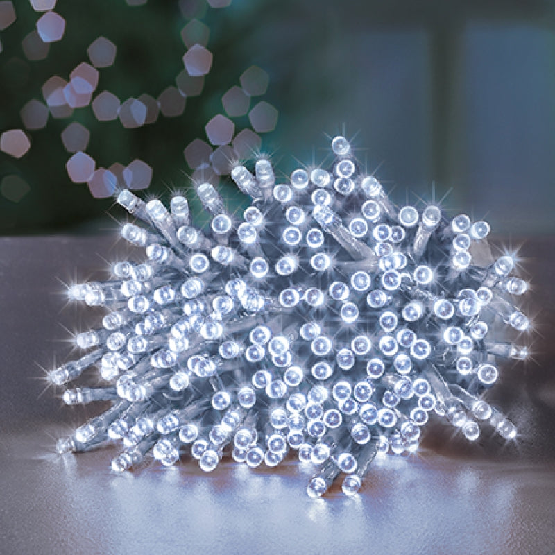 String of white LED lights on a reflective surface with blurred lights in the background