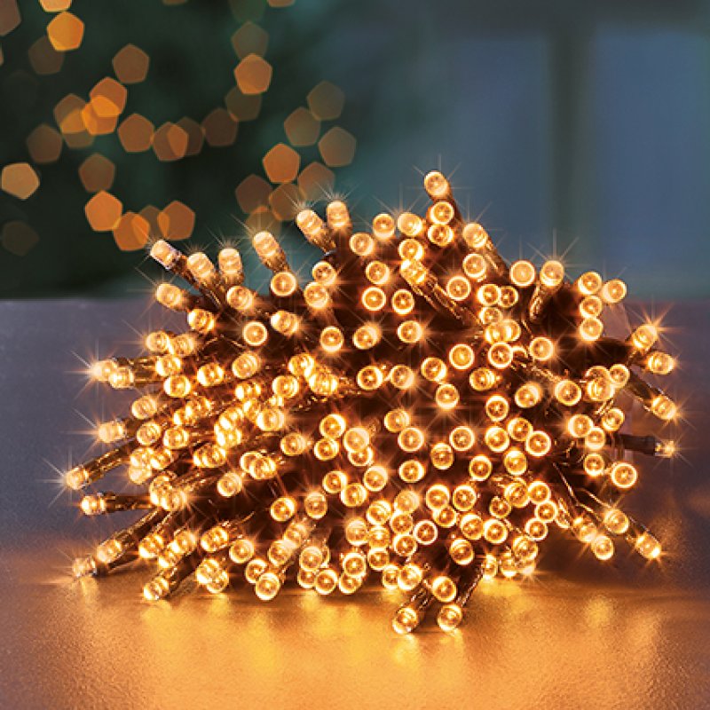String of vintage gold led lights on a reflective surface with blurred lights in the background