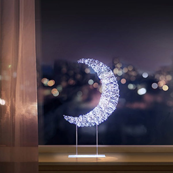 Decorative LED moon light on a stand with a cityscape in the background