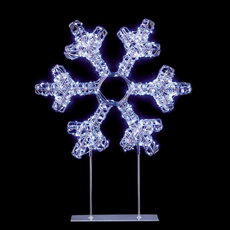 A snowflake-shaped decorative light fixture with six arms, glowing with cool white LED lights on a clear acrylic stand against a solid black background.