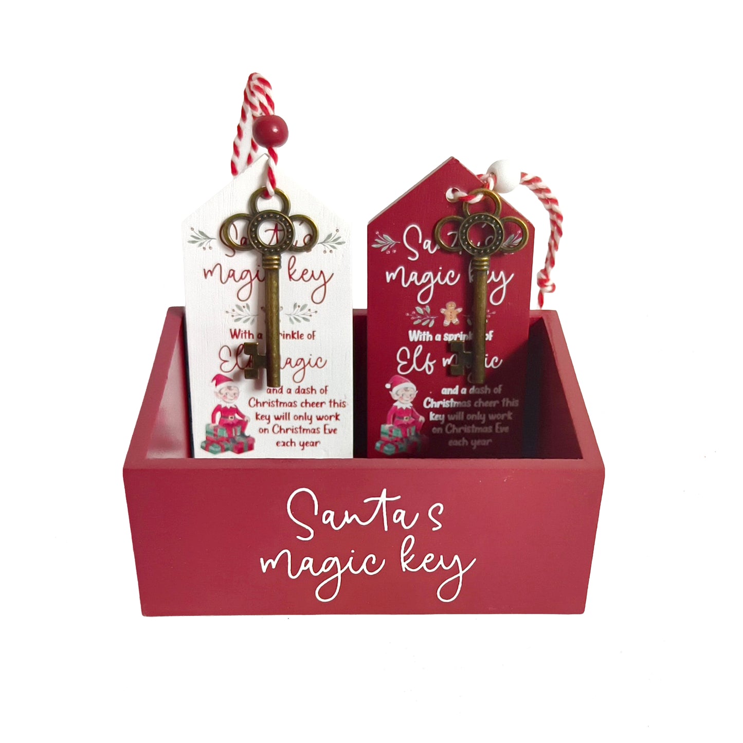 A red wooden gift box labeled 'Santa's magic key' holding two decorative key-shaped tags with red-and-white striped string and holiday illustrations. 