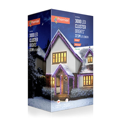 Premier 3000 LED cluster lights in a snowy house scene, shown in its retail packaging box against a white background.