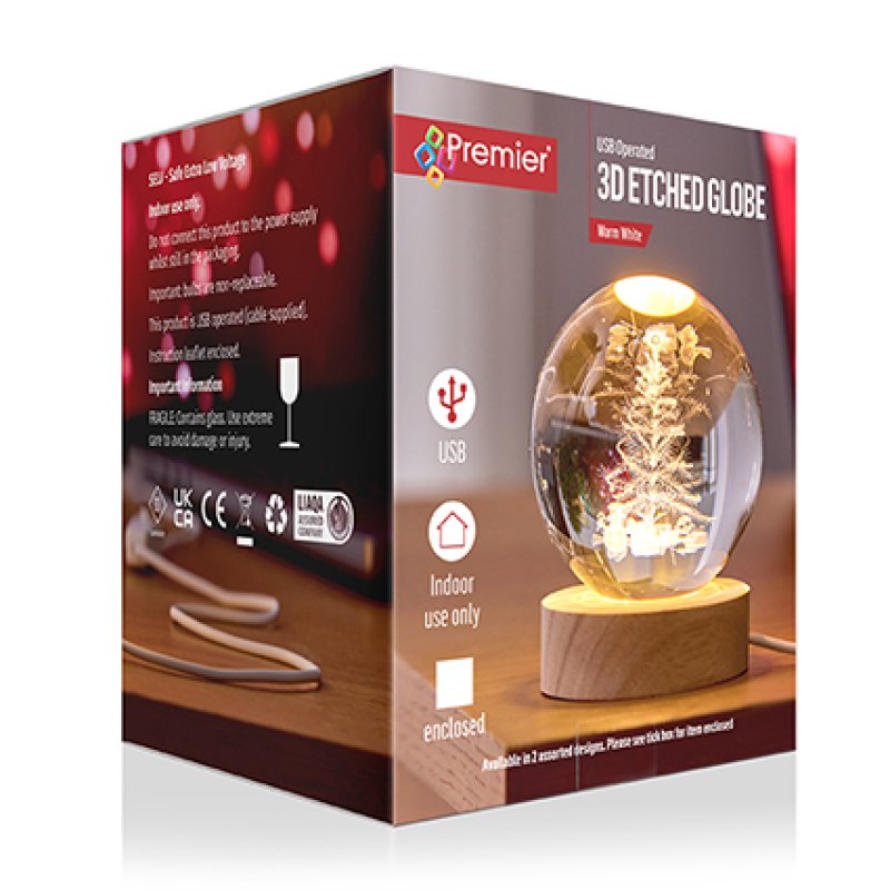 Premier 3D Etched Globe snow globe on a wooden base, shown in its retail packaging box. The box is brown and red with product details and a photo of the glowing white snow globe containing a miniature Christmas tree.
