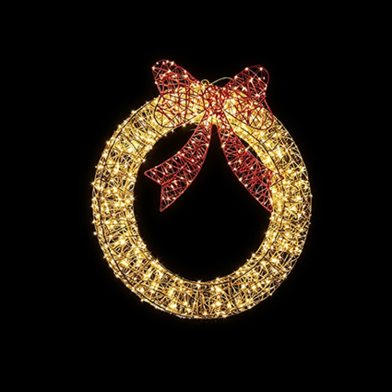 A circular golden wire wreath light fixture filled with warm white lights and accented with a red bow at the top, shown against a solid black background.