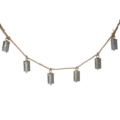 A string of matt silver cow bells with a rustic finish, hung on a jute rope.