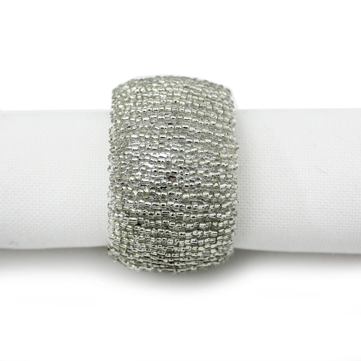 A wide, textured silver beaded napkin ring band displayed on a white fabric napkin against a white background.