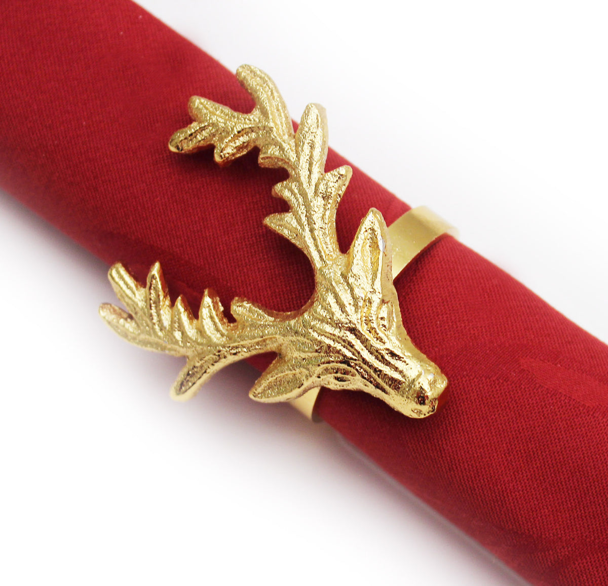 A gold deer head napkin ring with textured antlers, shown wrapped around a rolled red fabric napkin on a white background.