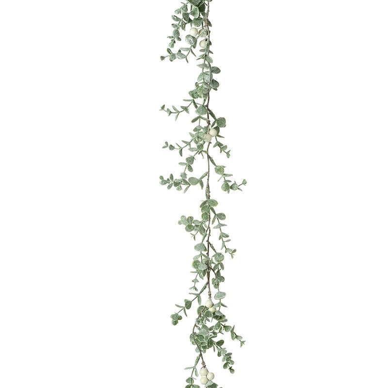 A garland of green leaves and white berries, fanned out to create a flat lay appearance.
